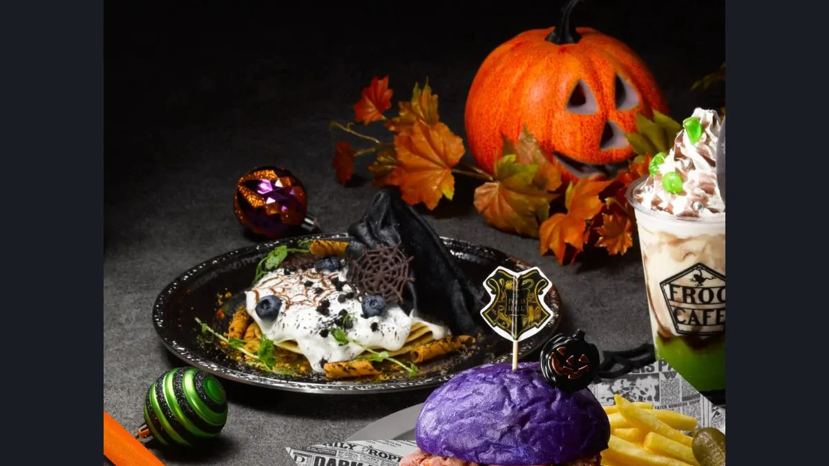 Dark Arts Halloween themed food including a purple Halloween burger, Dementor pancakes with black topping, a green and brown frog café milkshake, and jack-o'-lantern decorations.