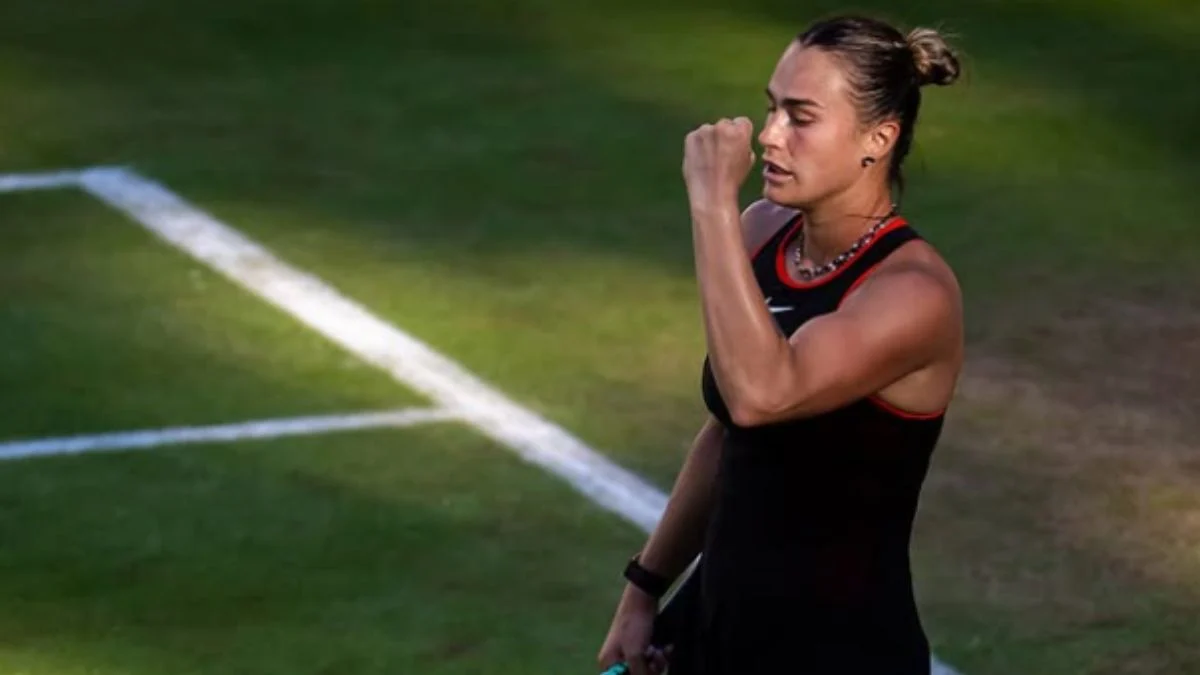 Tennis star Aryna Sabalenka pumping her fist on court during a match.
