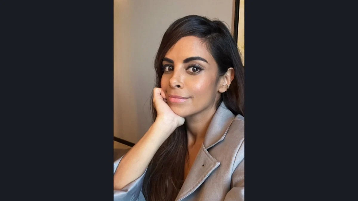 Collien Fernandes resting her chin on her hand in a light grey blazer