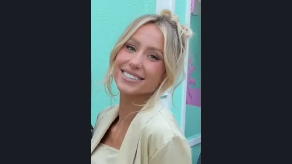 Alix Earle smiling in a light blazer during an outdoor appearance.