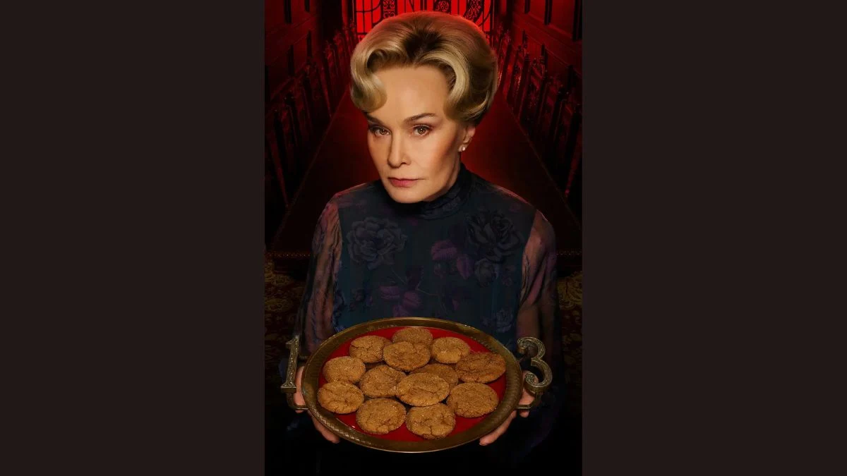 Jessica Lange holding a tray of baked goods with 13-shaped candles as Constance Langdon in American Horror Story: 13.
