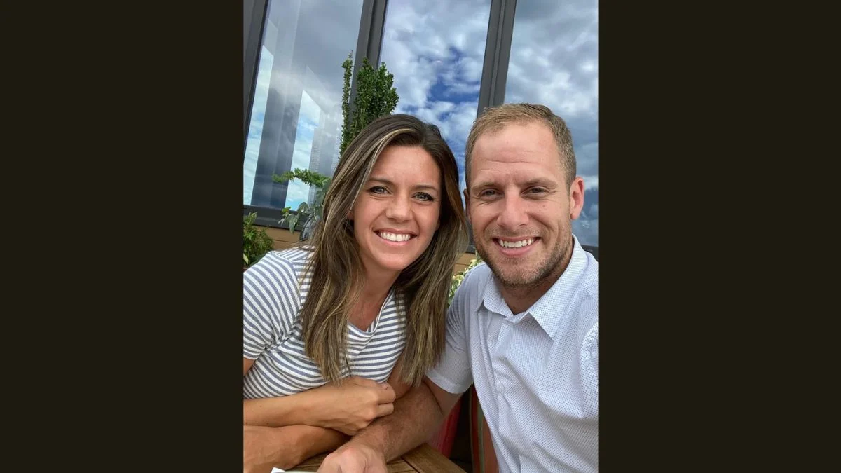 Couple photo of smiling Ashley Flynn and her husband Caleb Flynn seated together outdoors.