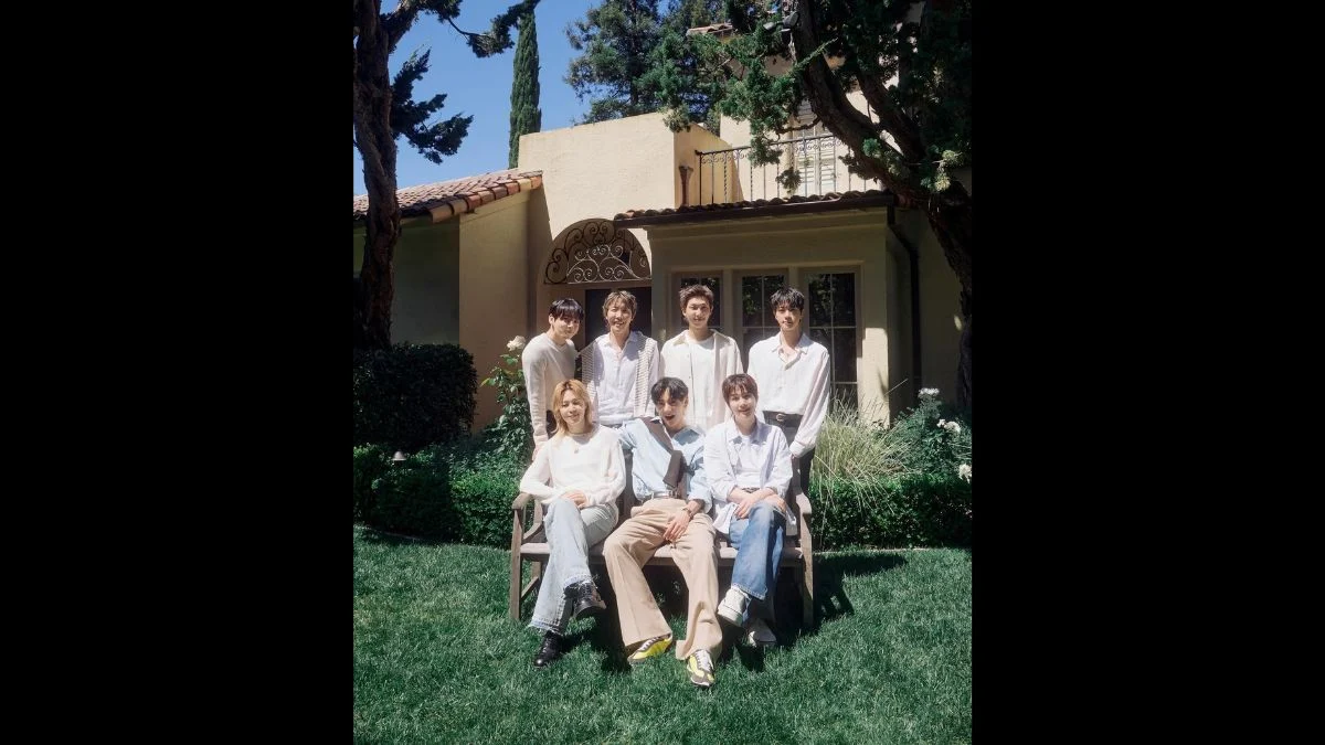 All seven members of BTS posing together outdoors in light casual clothing during the ARIRANG era