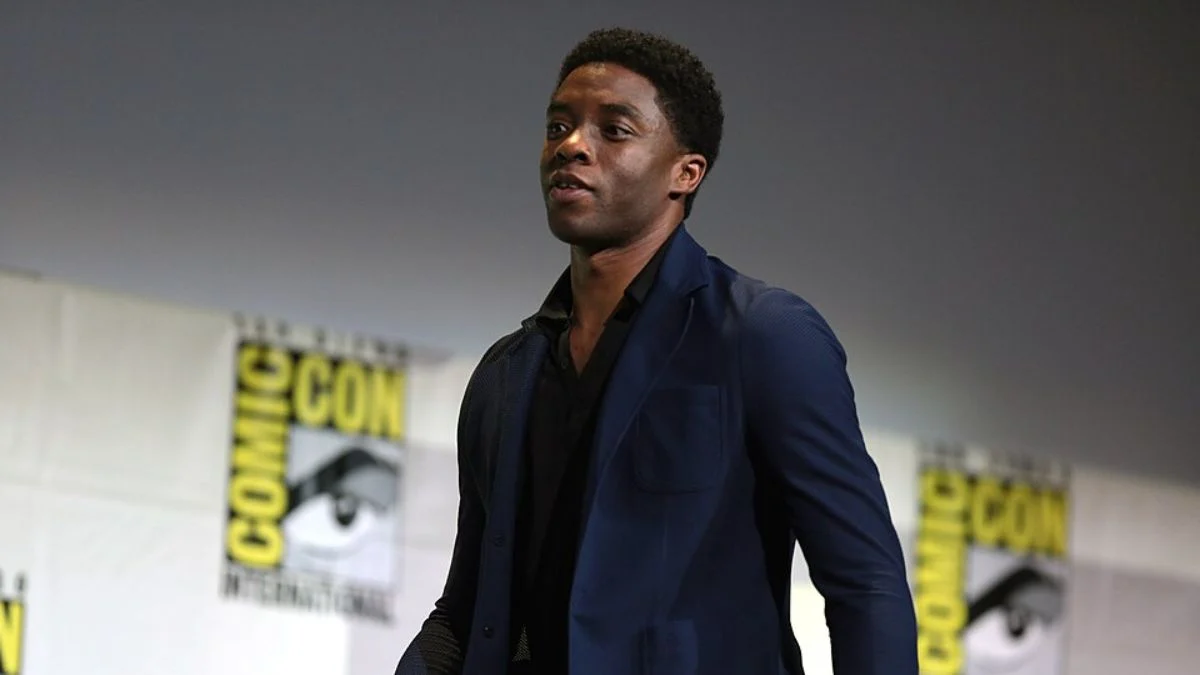 Actor Chadwick Boseman speaking on stage at a Comic-Con event.