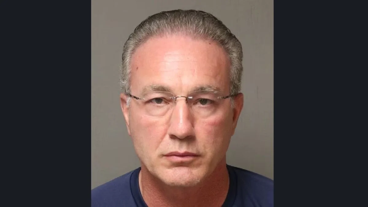 Booking mugshot photo of Dr. Richard Thomas Arriviello wearing glasses