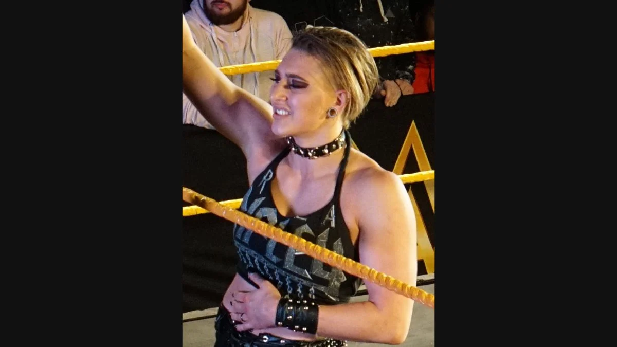 WWE superstar Rhea Ripley making her entrance in the ring with leather gear and spiked collar