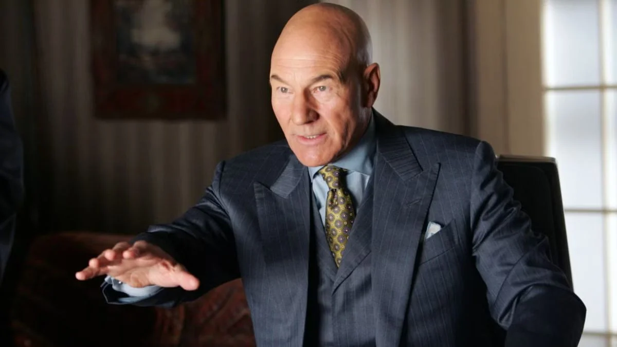 Patrick Stewart playing Professor Charles Xavier in a tailored suit leaning forward