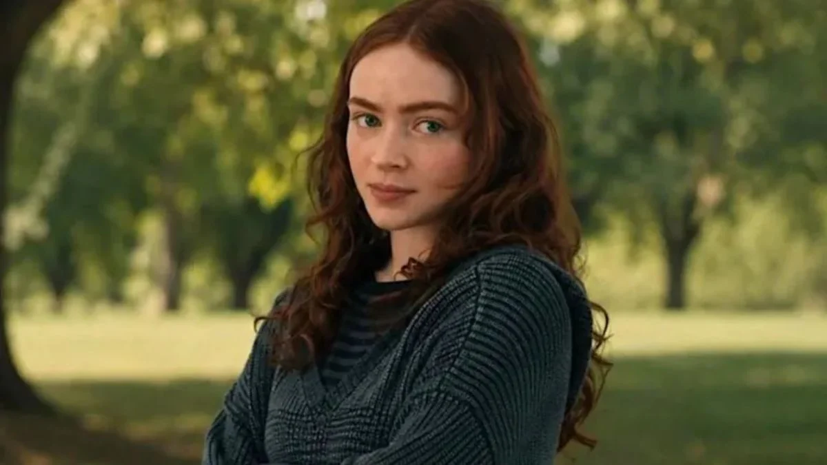 Sadie Sink looking directly at the camera outdoors with red hair, portraying Jean Grey in Spider-Man: Brand New Day.