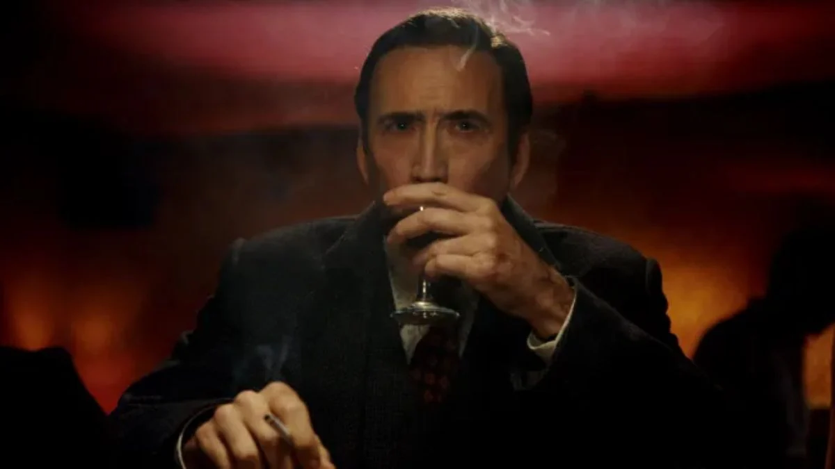 Nicolas Cage as Ben Reilly sipping a drink in a shadowy room in a scene from Spider-Noir on Prime Video.