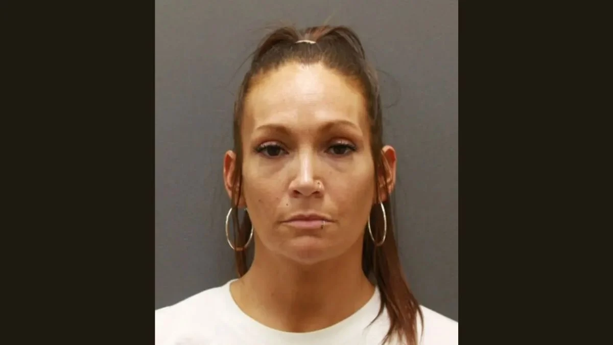 Mugshot of Cyrena Quast wearing a white top and hoop earrings following her Minnesota arrest.