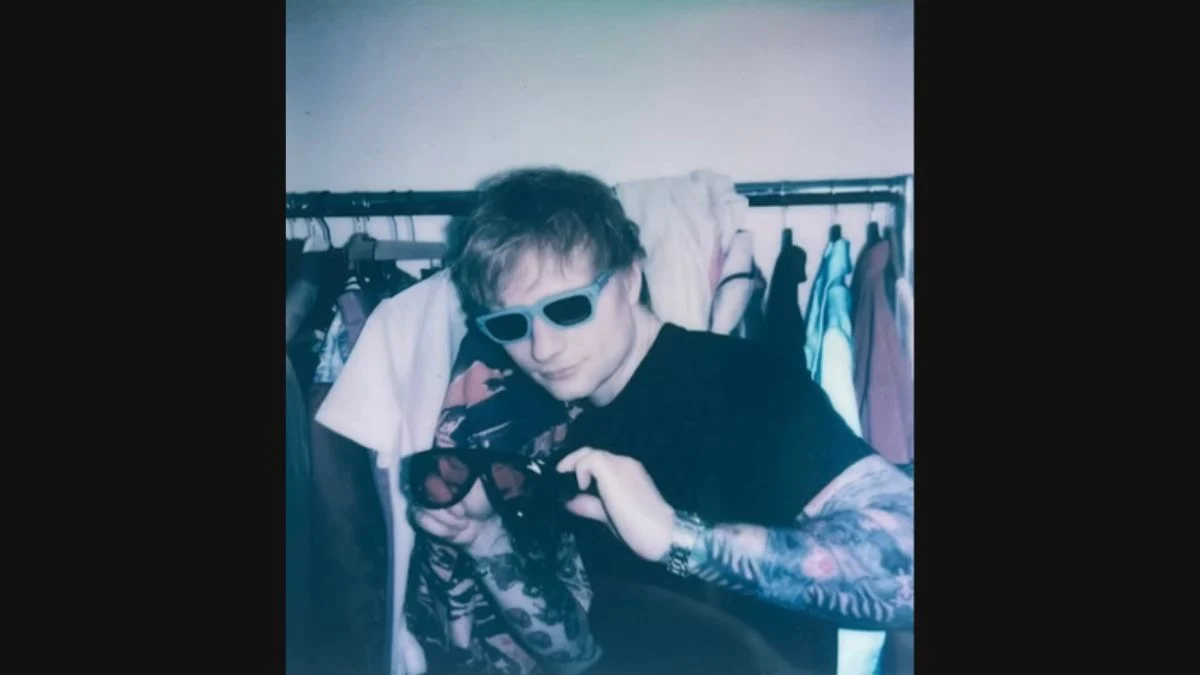 Pop singer-songwriter Ed Sheeran wearing blue sunglasses and posing backstage during his 2026 Loop Tour