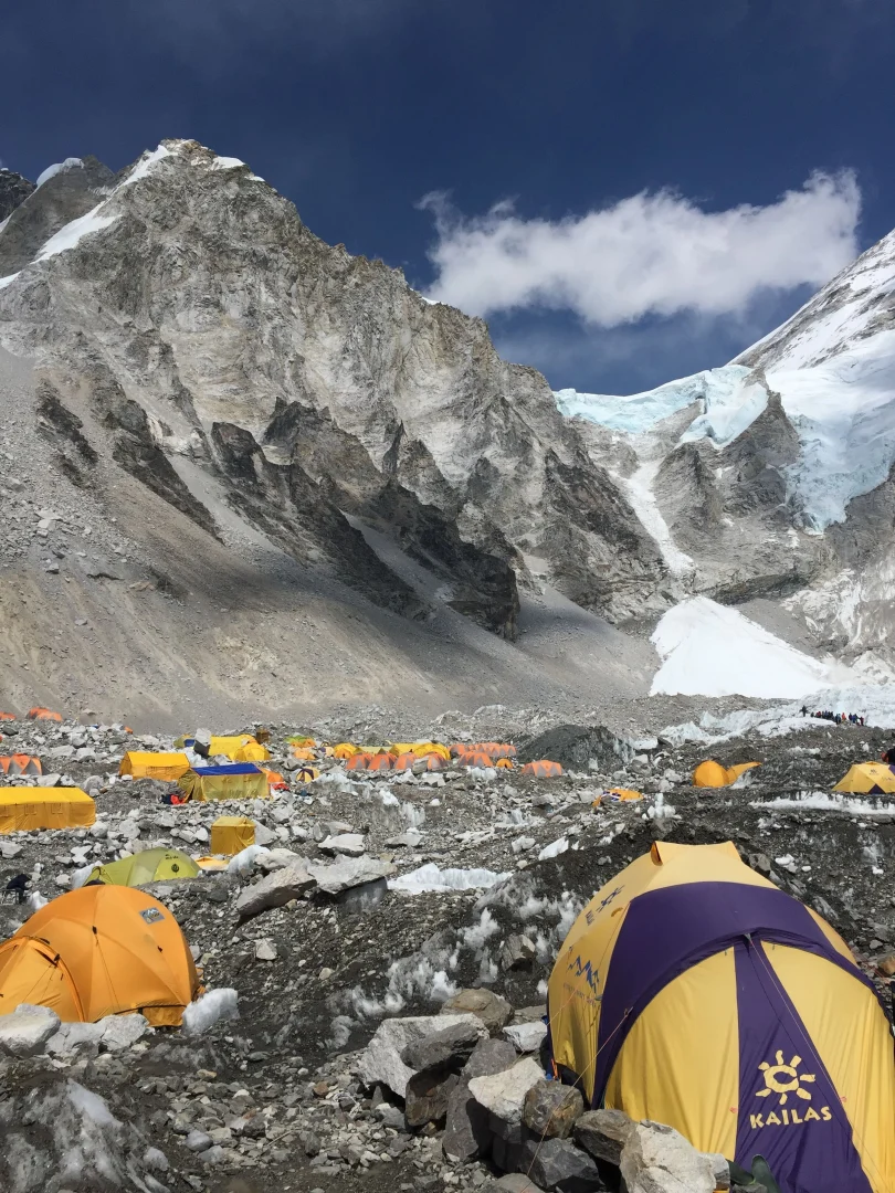 Expedition tents pitched on the rocky terrain of Everest Base Camp at the foot of towering Himalayan mountains