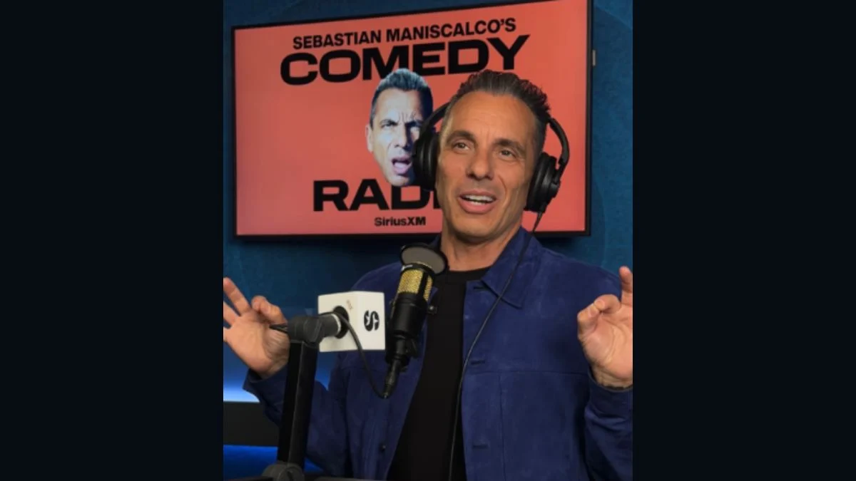 Sebastian Maniscalco holding a microphone in front of a SiriusXM Comedy Radio backdrop.