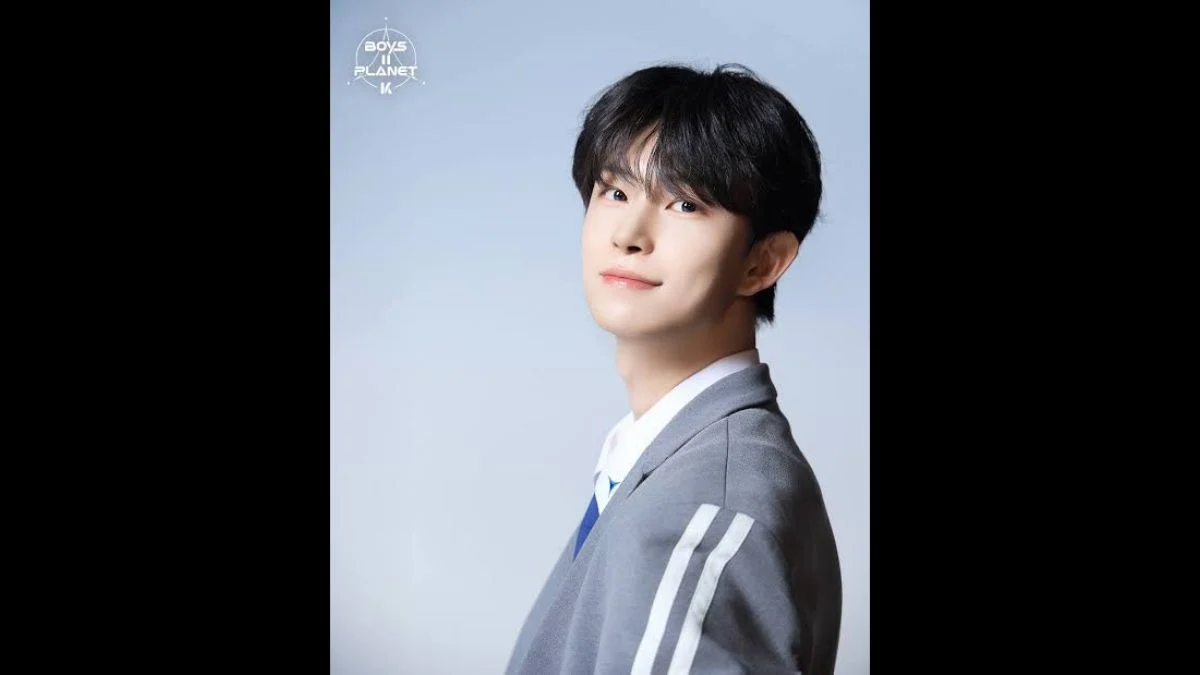K-pop idol Geonwoo posing in a grey school uniform jacket from BOYS II PLANET