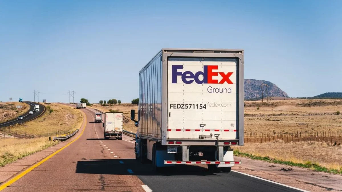 FedEx Ground delivery truck driving down a open highway carrying cargo packages