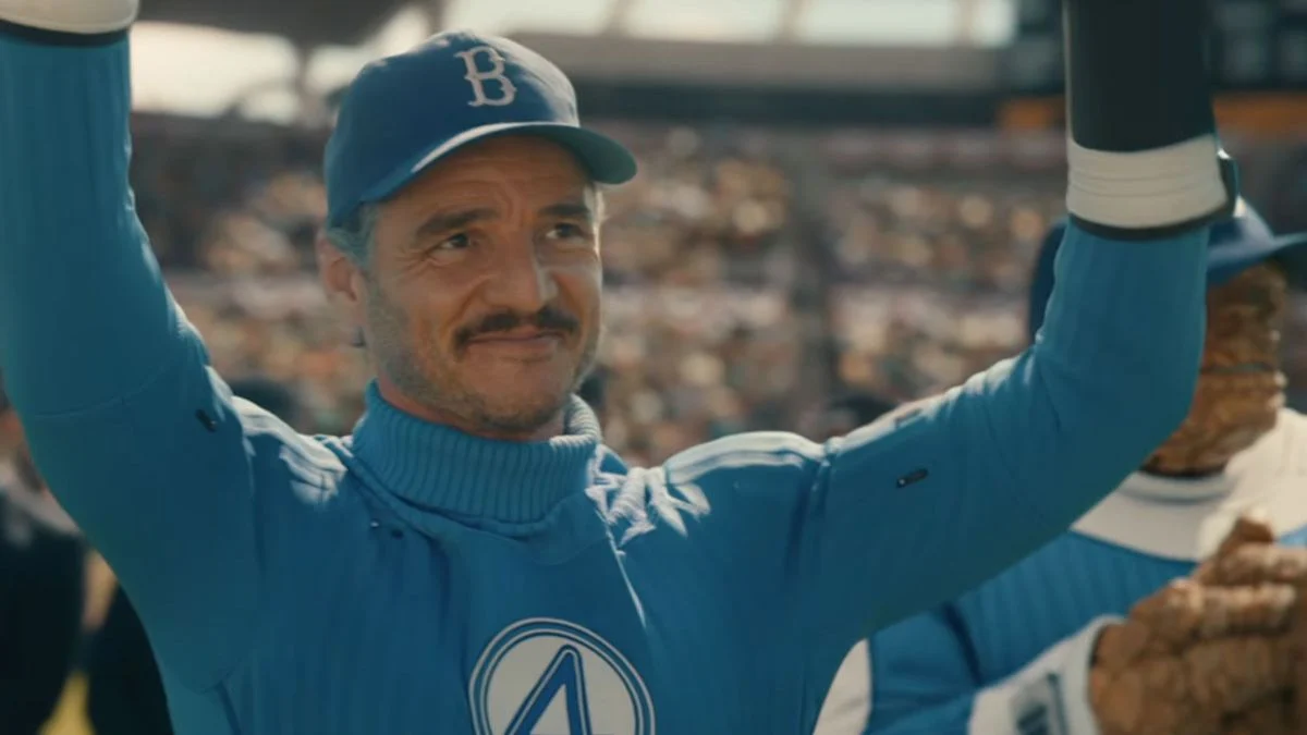 Pedro Pascal as Reed Richards wearing a blue suit and Brooklyn Dodgers cap raising his hands in a stadium in Avengers: Doomsday