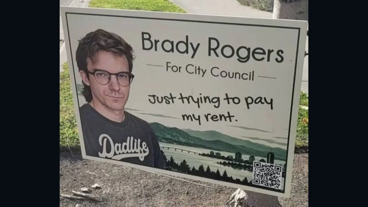 Brady Rogers campaign lawn sign featuring his photo and the slogan Just trying to pay my rent in Kelowna, B.C.