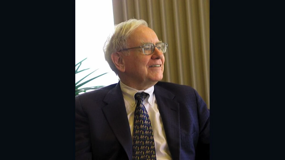 Billionaire investor Warren Buffett smiling while seated in a suit and tie