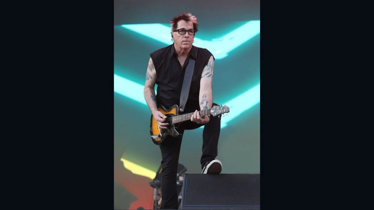 The Offspring guitarist Noodles performing live on stage with an electric guitar