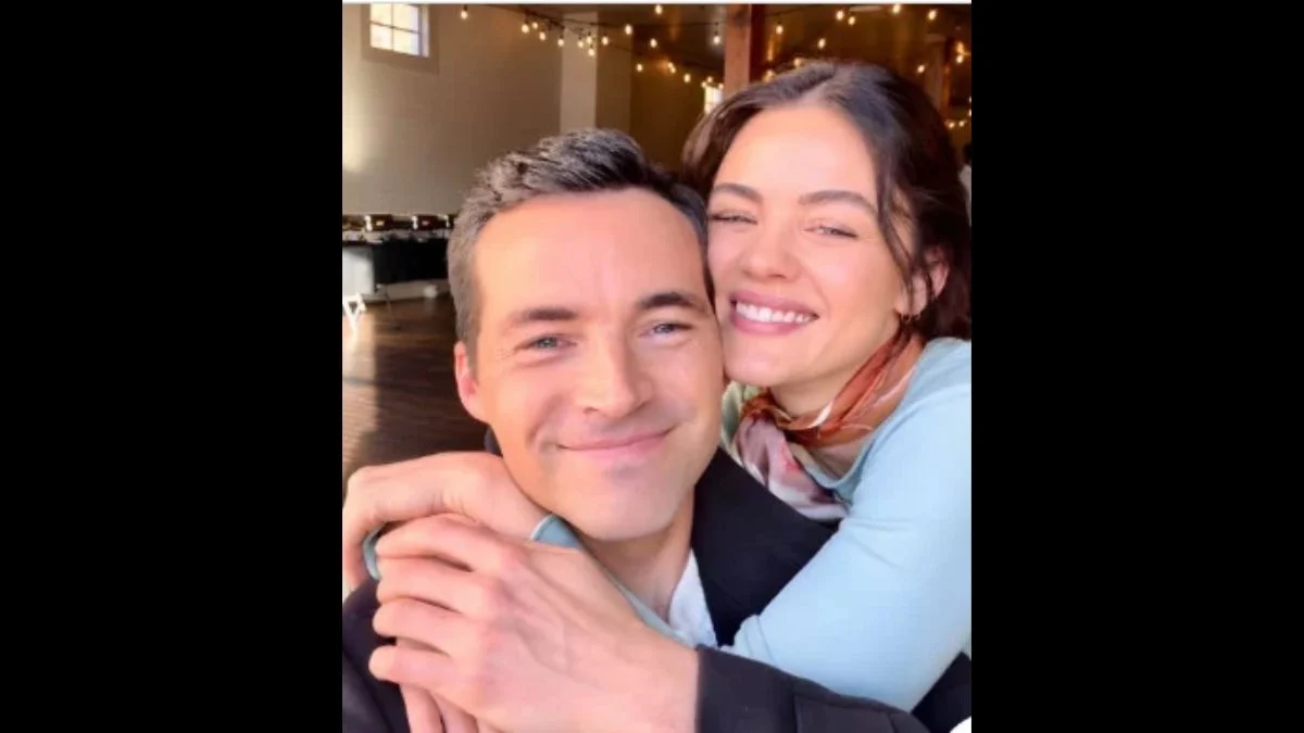 Lucy Hale smiling and hugging Ian Harding from behind in a selfie video shared on TikTok