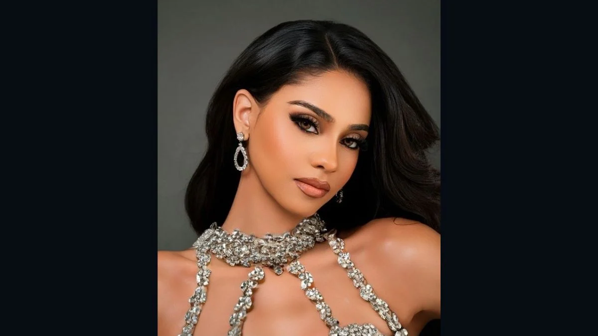 Close-up portrait of Jihan Mohin Dimachk wearing an intricate crystal neckline and drop earrings against a dark background.