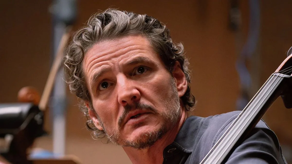 Pedro Pascal looking focused and holding a cello in a scene from the drama film Behemoth!