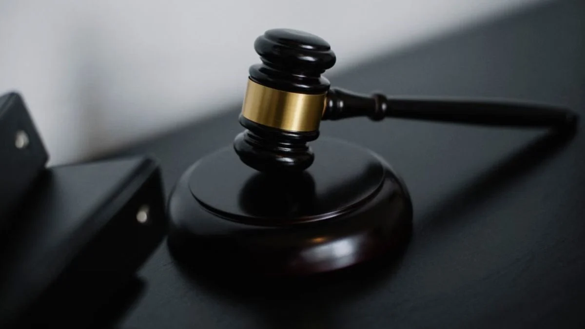 Wooden judge gavel on a dark wooden surface symbolizing legal proceedings and court decisions.