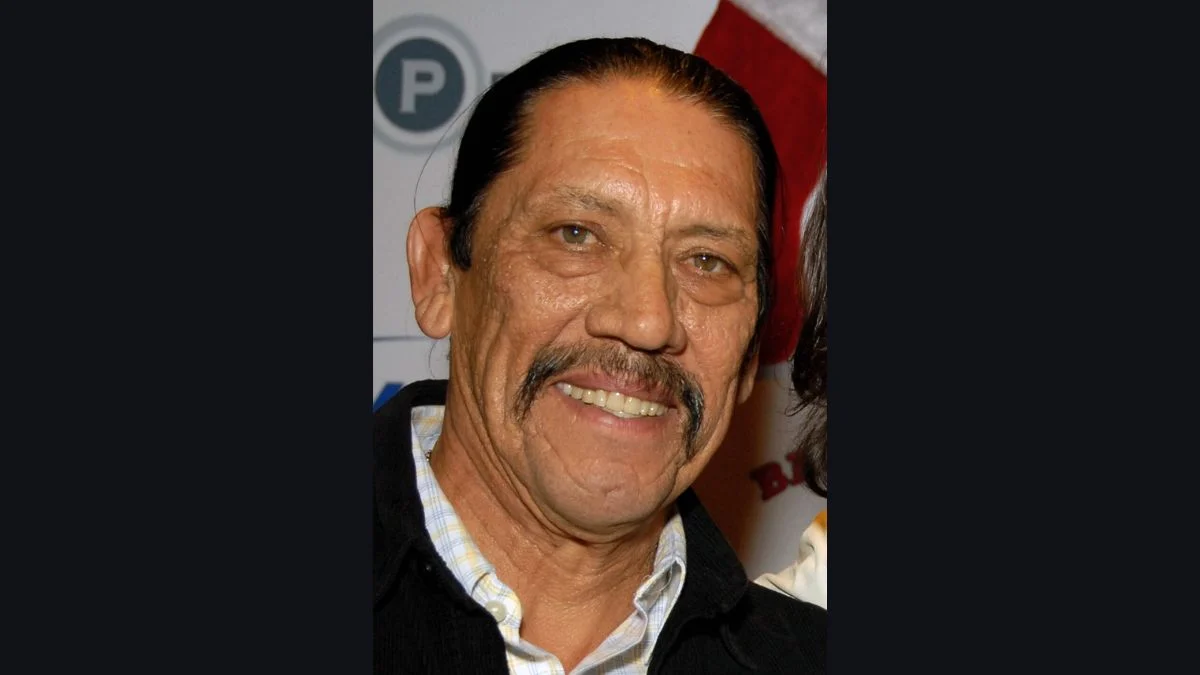 Danny Trejo smiling while posing at a public event.