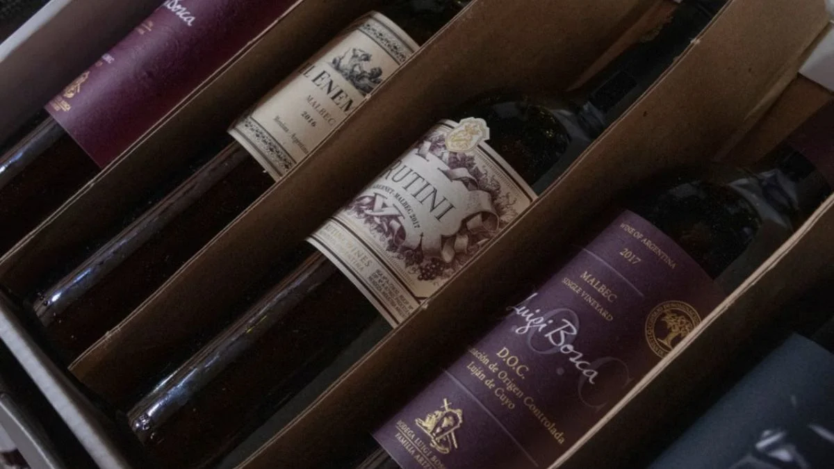 Several high-end wine bottles carefully packaged and aligned inside cardboard shipping boxes.