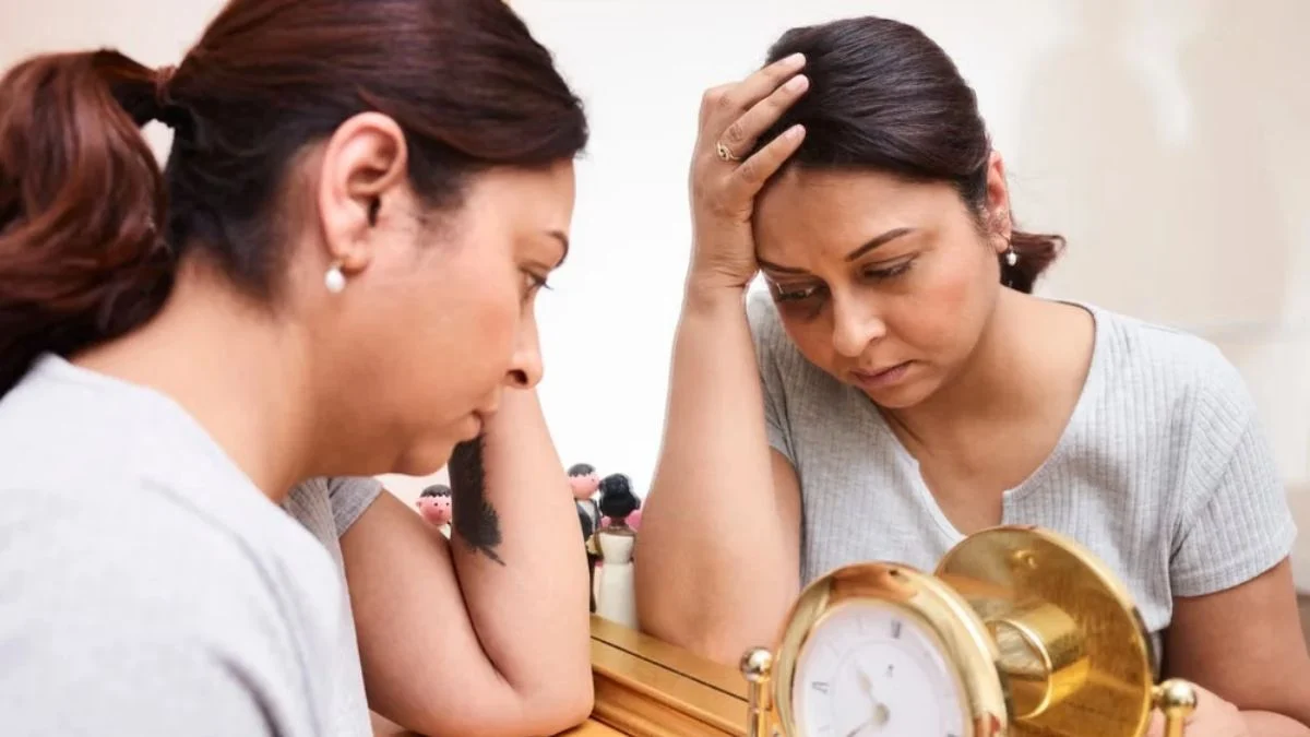 Woman looking tired and stressed while looking at her reflection in a mirror