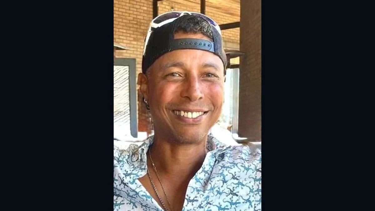Frontman Darik Pearson smiling outdoors wearing sunglasses on a backward cap and a printed button-down shirt